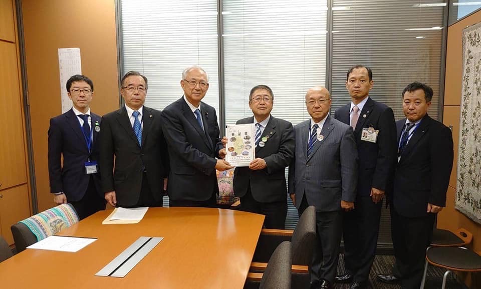 要望書を一緒に持つ市長と男性1名、関係者の男性5名が横一列に並んでいる記念写真