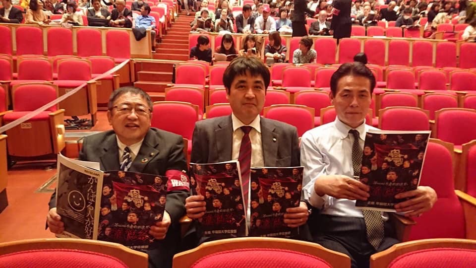 パンフレットを持って椅子に座る市長と関係者の男性2名の写真