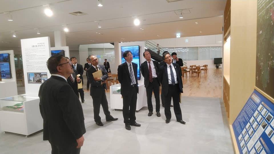 地図が貼られた壁の方を見ながら視察する様子の市長と関係者の方々の写真