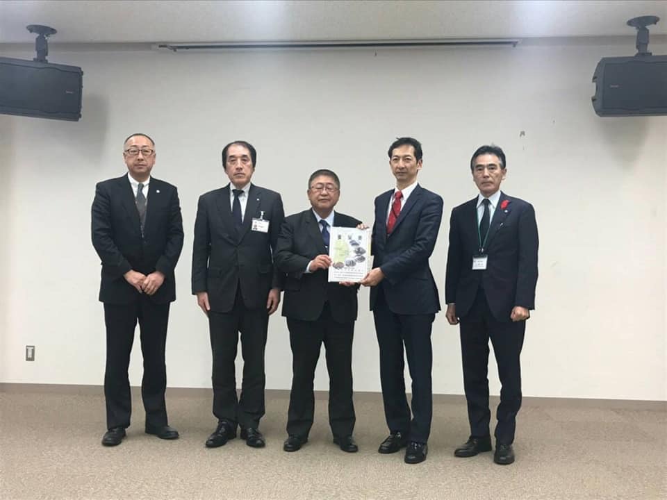要望書を一緒に持つ市長と男性を中心に、関係者の男性3名が横一列に並んでいる記念写真