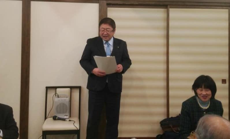 引き戸の前に立ち両手で持った資料を見ながら話をしている様子の市長の写真