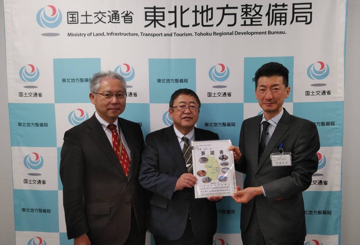 要望書を一緒に持つ市長と男性と、関係者の男性がもう1名写っている写真