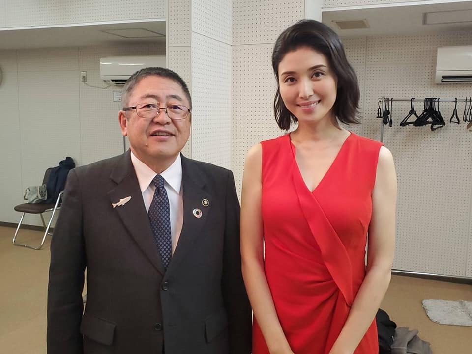 赤いドレスを着た橋本マナミさんと市長が記念撮影をしている写真