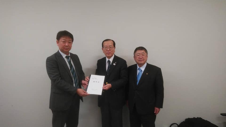 ソフトバンク株式会社の部長と本田遠野市長が一緒に要望書を持ち、市長と横一列に並んで立っている写真