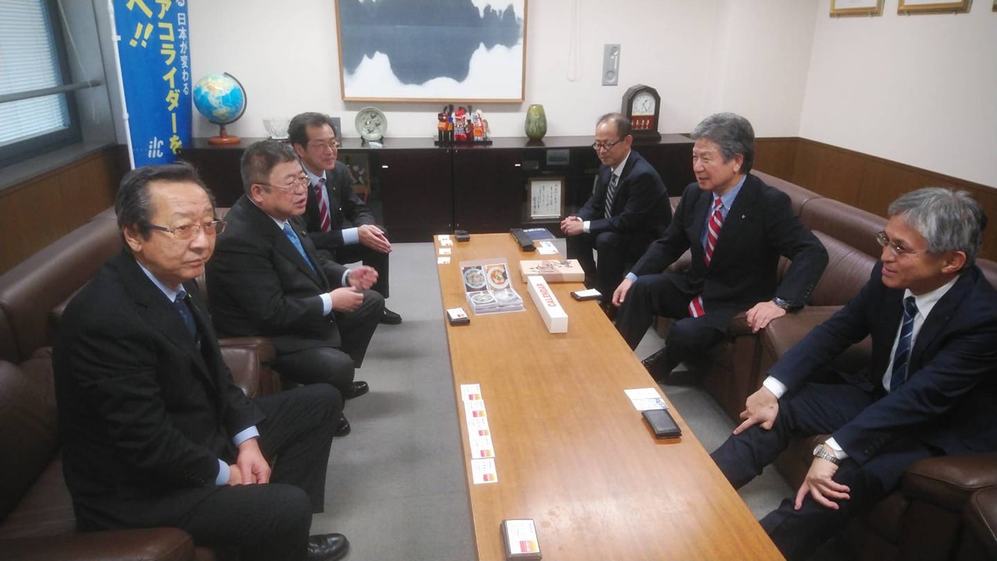 室内の横長のテーブルを挟んで東北経済連合会の向田吉広副会長と2名の関係者と市長と2名の関係者が向かい合って座り話をしている様子の写真
