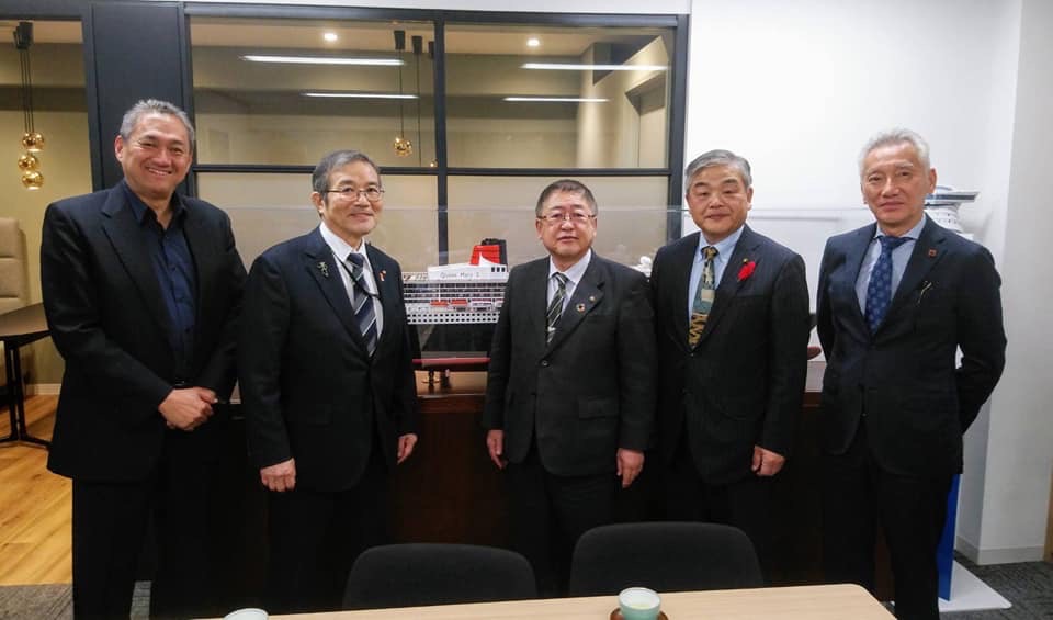 スーツを着た市長を含む5名の男性が横一列に並んでいる記念写真