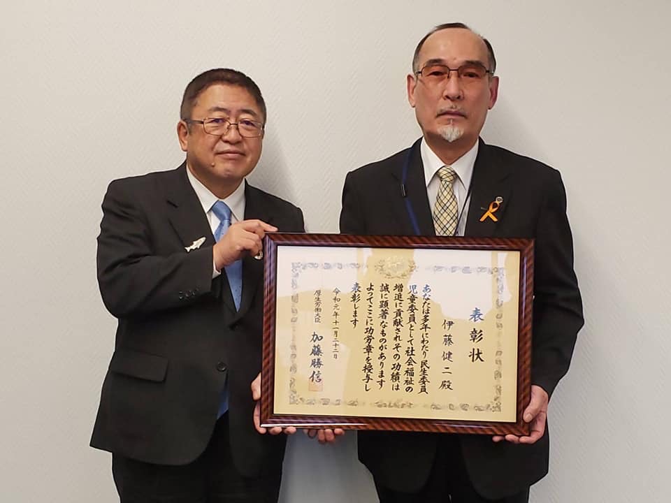 賞状の額縁を一緒に持つ市長と男性の記念写真