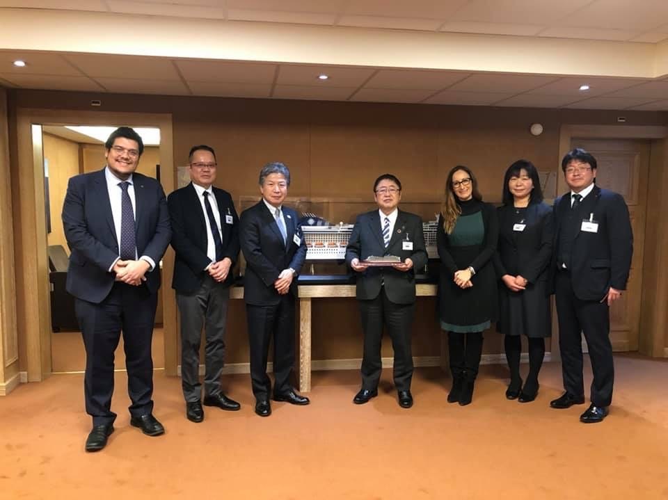 クルーズ船の模型の前で横一列に並ぶ市長と関係者の方々の記念写真