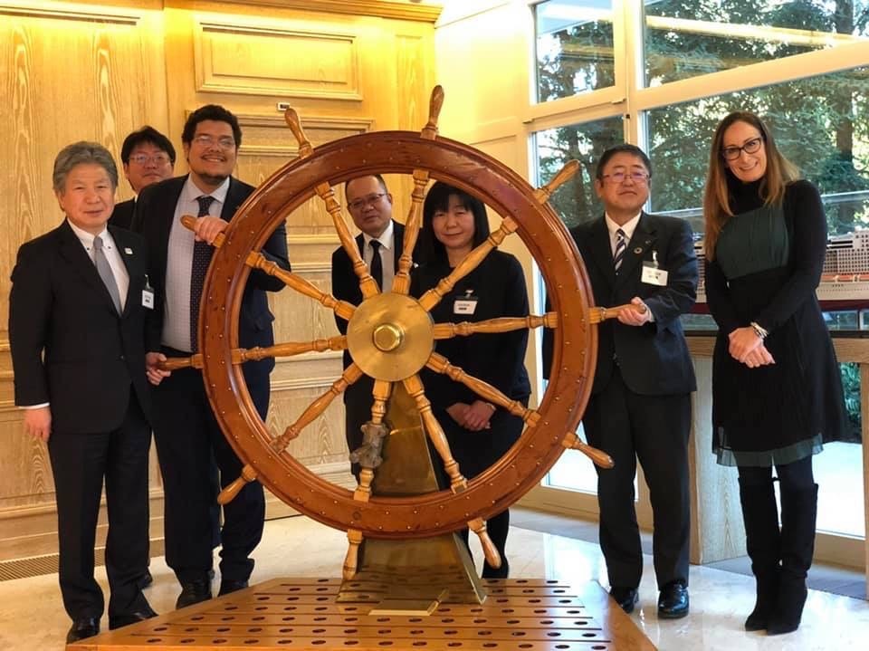 飾られている大きな舵輪の周りに立つ市長や関係者の方々の記念写真
