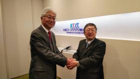 片倉コープアグリ株式会社の社名が書かれた壁際で両手で握手している男性と市長の写真