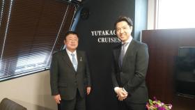 両手をお腹の前で組んでいる男性と市長が並んで写っている記念写真