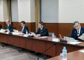 長机の席に着き手元の資料を見る様子の市長と3名の男性の写真