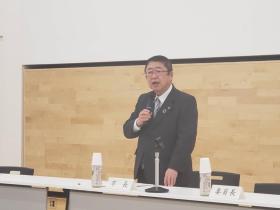 長机の席で立ちマイクを持って話をしている市長の写真