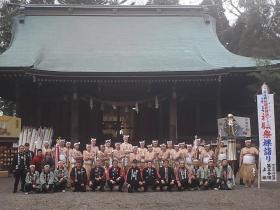 しめ縄が掛けられたお堂の前で、法被を着た方々が前列でしゃがみ、ふんどし姿の方々が後列で立って並んでいる記念写真