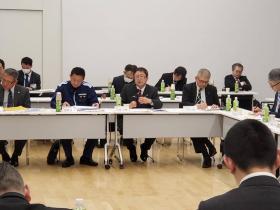 コの字型に並べられた長机の席に座っている市長がマイクを持ち話をしている委員会の様子の写真