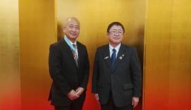 金屏風の前で前宮古市参与兼都市整備部長の小前繁さんと市長が立って並んでいる近年写真