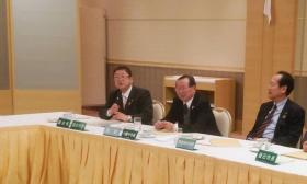 長机の席につきマイクを持って話をする様子の市長と、男性2名を写した写真