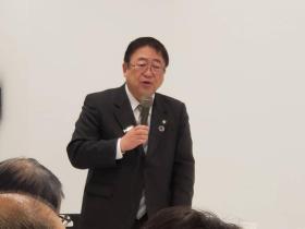 右手にマイクを持って話をする様子の市長の写真