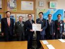国土交通省の池田豊人道路局長を岩手県、盛岡市合同の5人で訪問し、代表の方が 要望書を渡している写真