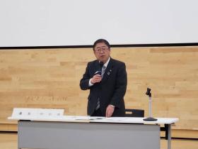 会場で市長が自席で立ち、収支状況や事業計画について述べている写真