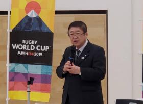 上部にダイヤモンド富士を表すイラストが描かれ、中央部にRUGBYWORLDCUPJAPAN日本2019と書かれ、下部は青、紫、橙、黄の4色のボーダーラインが塗られた幟の横に市長が立ち、大会を盛り上げた成果について述べている写真