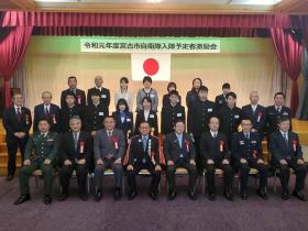 入隊予定者10人の方とその関係者の方々の計26人が3列に並んで撮影した写真