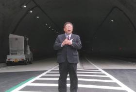 完成したトンネルの前で市長があいさつを述べている写真
