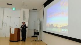 画面が映されたスクリーンを見ながら話をする様子の市長の写真