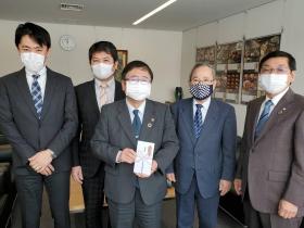 寄附金の封筒を持つ市長を中心に両側に立つ宮古市異業種交流会の関係者4名の記念写真