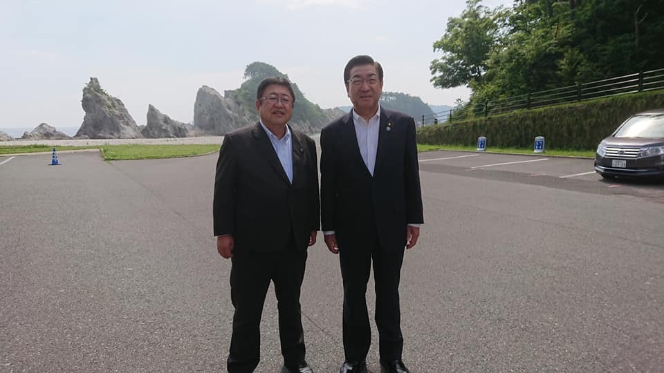 浄土ヶ浜をバックに、老松大仙市長と市長が並んで立っている写真