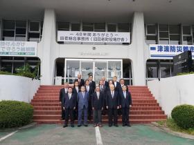 施設の階段の前で3列になって整列する市長や関係者の方々の記念写真