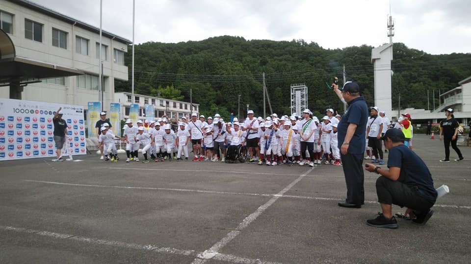 スターターピストル持った右手を上にあげた市長が、スタート位置にいる参加者の方向を見ながらスタートの合図を送っている様子の写真