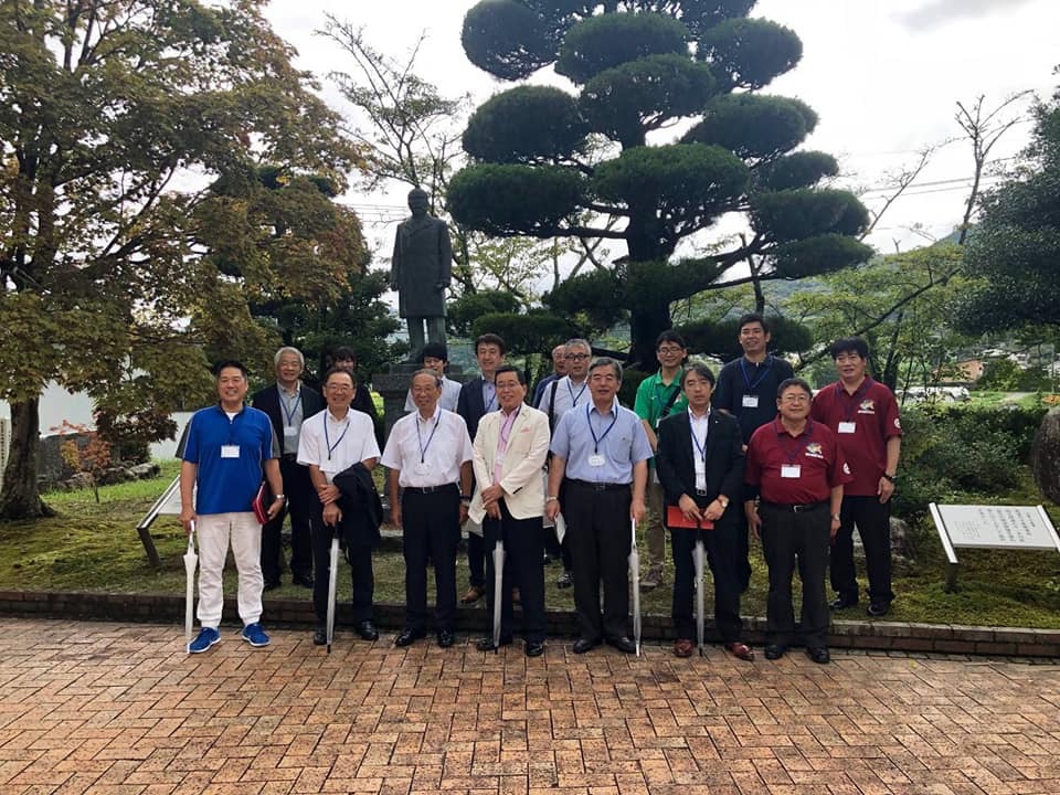 銅像が立っている公園で、森・滝・渚全国協議会に参加した方々の集合写真