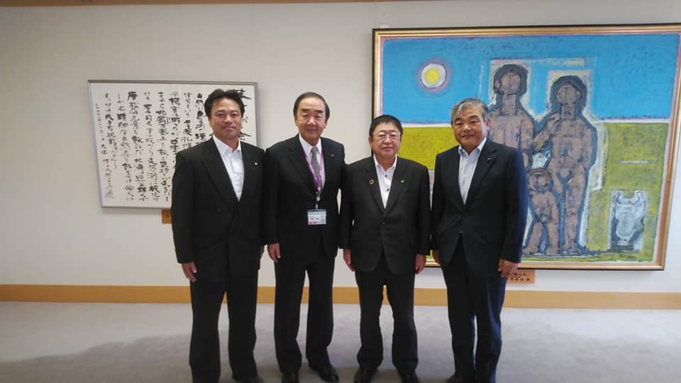 絵画が飾られた壁の前で、横一列に並ぶ市長と苫小牧市の岩倉博文市長、金澤俊議長、宮古市議会の古舘議長の記念写真