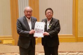 自由民主党 鈴木俊一総務会長に市長が道路整備の促進に関する要望書を渡している写真