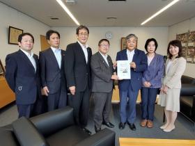 宮古市議会教育民生常任委員会の男性4人、女性2人が市長を訪れ、男性1人が市長に保健分野の提言書を渡している写真