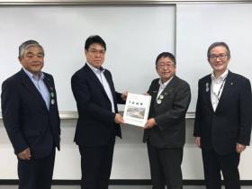 三陸国道事務所を、市長の他2人が訪れ、市長が三陸国道事務所の方に要望書を渡している写真