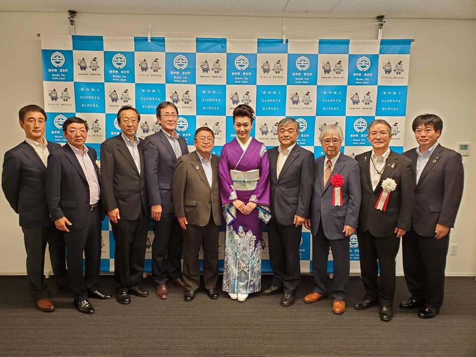 市川由紀乃さんを中心に、完成披露発表会に出席した関係者10名が並んだ集合写真