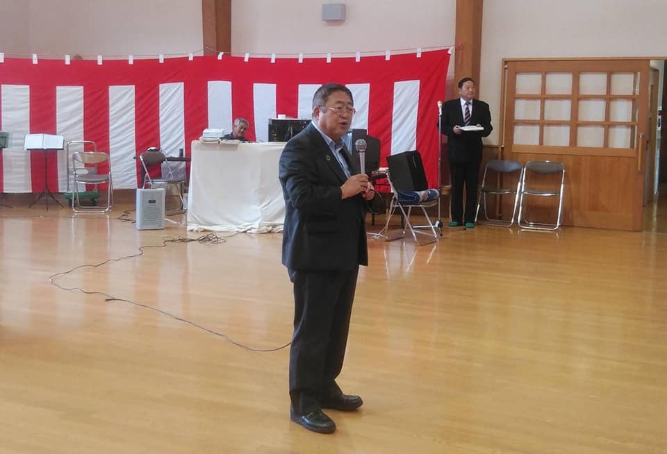紅白幕が張られた会場で、マイクを持ち話をする市長の写真