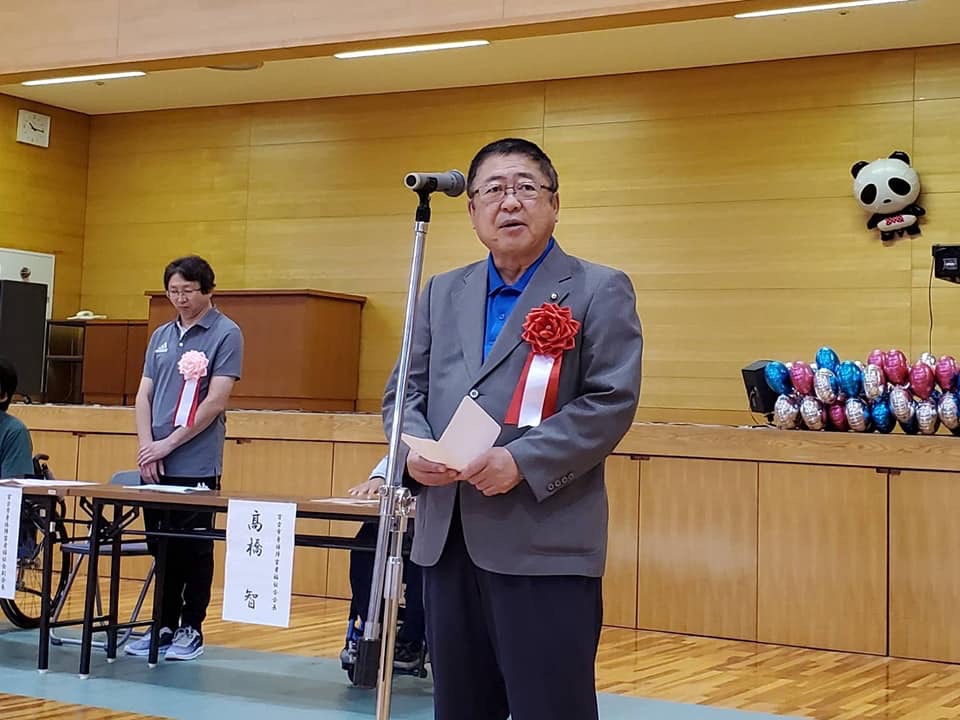 胸章を付けた市長がスタンドマイクの前に立ち話をしている様子の写真