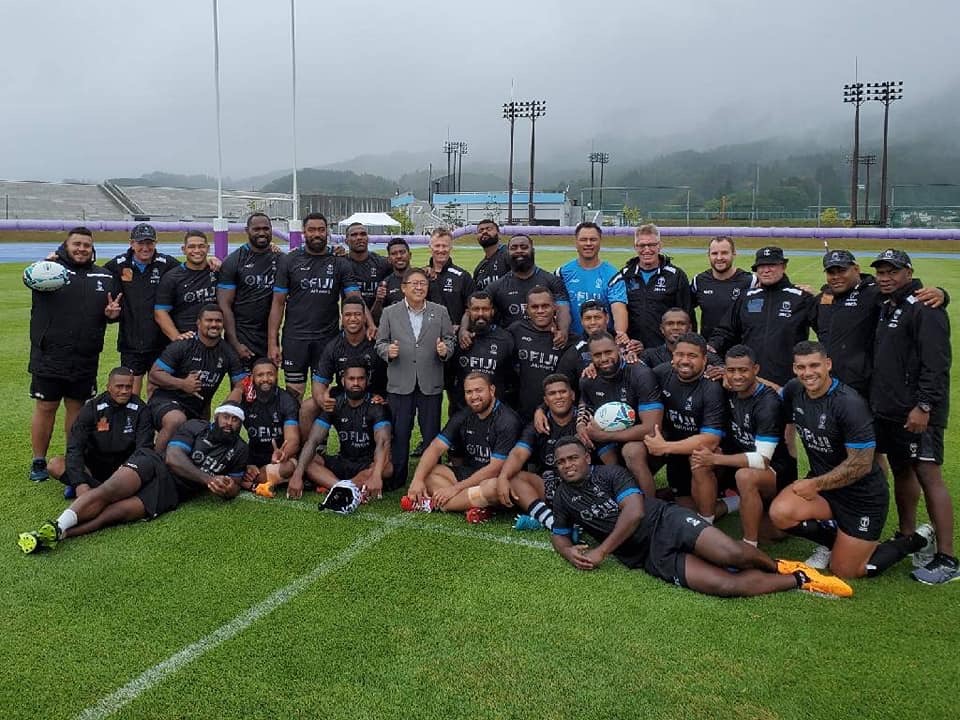 グラウンドで撮影されたフィジーの代表選手30名弱と市長の集合写真