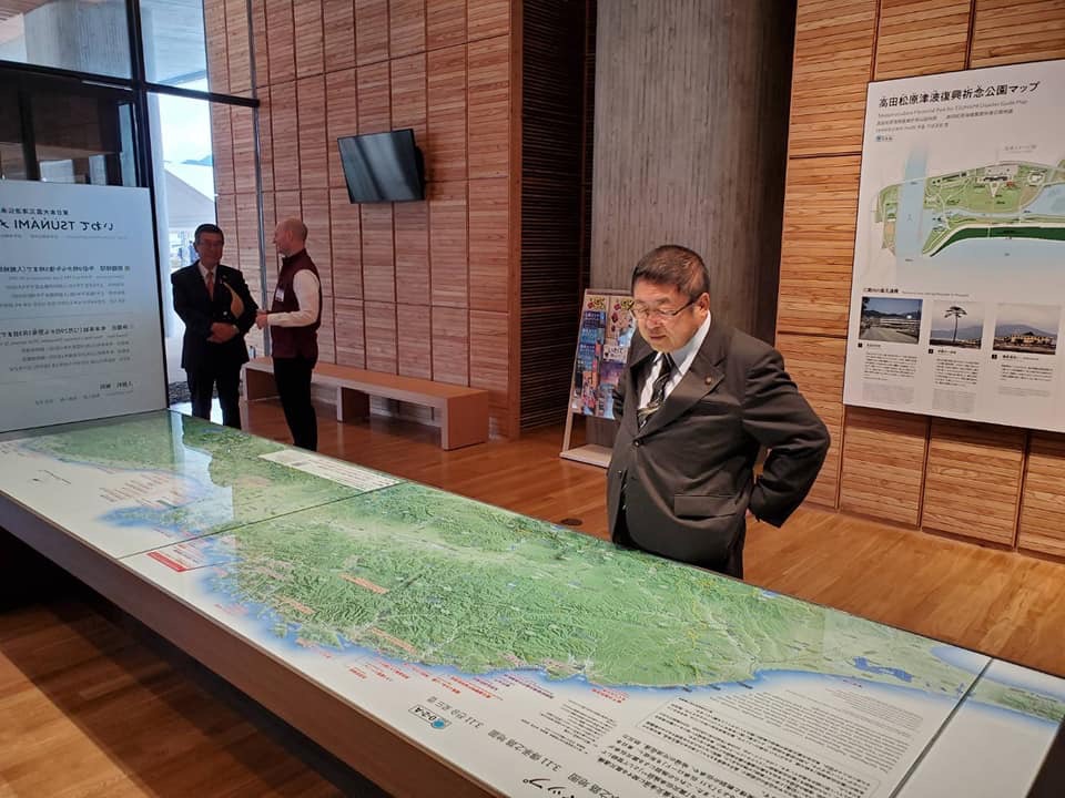 東日本大震災津波伝承館に展示されている地図が描かれた大きな資料を見ている市長の写真