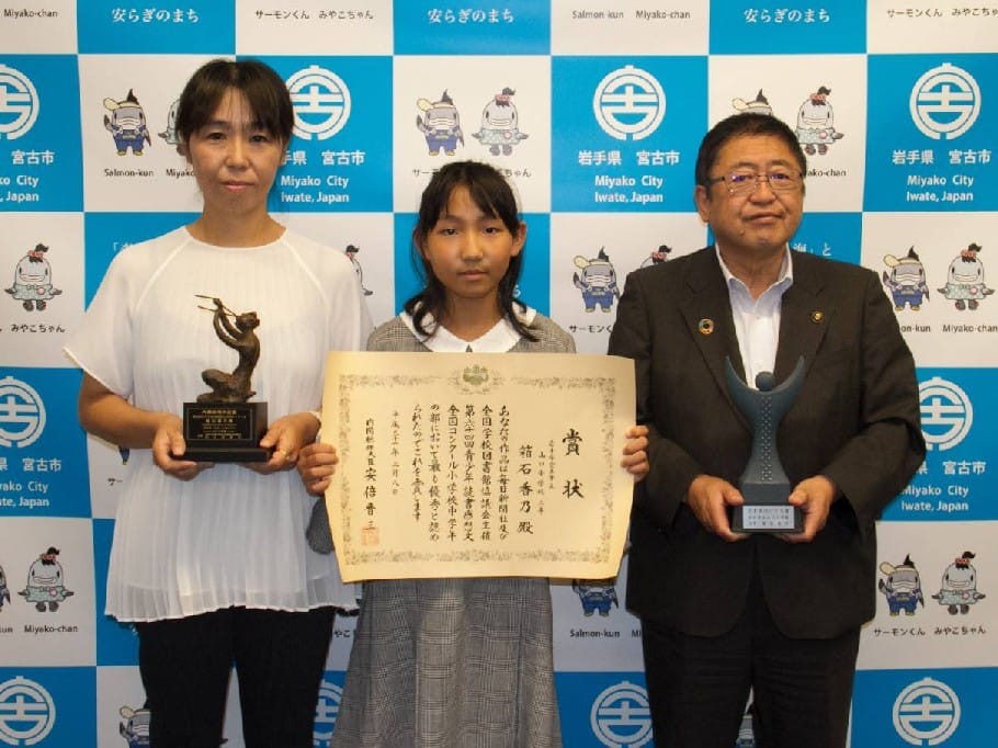 宮古市の会見パネルの前に立つ賞状を持った箱石香乃さんと、トロフィーを持ったお母さんと市長の写真