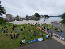 清掃活動に参加した方々と浄土ヶ浜全体を上空から撮影した写真