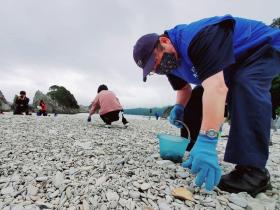 市長が紺色の帽子を被り、同色の作業着を着て、浄土ヶ浜園地のゴミを拾っている写真