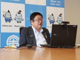 市長が自席で座って、ノートパソコンで青山学院大学・青山学院女子短期大学の皆さんと オンラインミーティングをしている写真