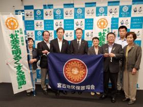 宮古地区保護司会と書かれた旗を持ち、社会を明るくする運動を書かれた幟を持ち、市長と盛岡保護観察所の五十嵐達所長と宮古地区保護司会の皆さんの8人で並んで撮影した写真