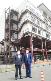 津波遺構のたろう観光ホテルを背景に市長と菅家一郎復興副大臣が並んで撮影した写真