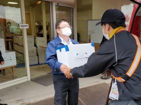 市長がウミネコミヤコの潮風便の段ボールを宅配業者の方に渡している写真
