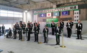 開通式が行われた室内の会場で大島理森衆議院議長、御法川信英国土交通副大臣、鈴木俊一衆議院議員、木戸口英司参議院議員、横沢高徳参議院議員をはじめ、市長他、多くの関係者が白の胸章をつけて2列に並んでテープカットをしている写真